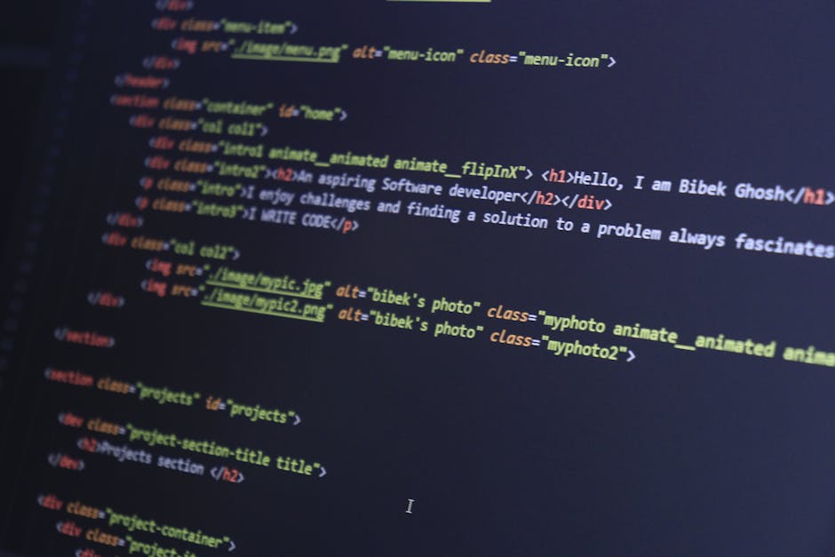 A person working on a laptop displays a dark-themed coding interface with lines of colorful code on the screen. The individual is using both hands to navigate or type, seated at a desk or table. The b